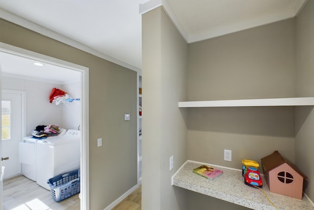 interior space featuring washing machine and dryer, crown molding, and light hardwood / wood-style flooring