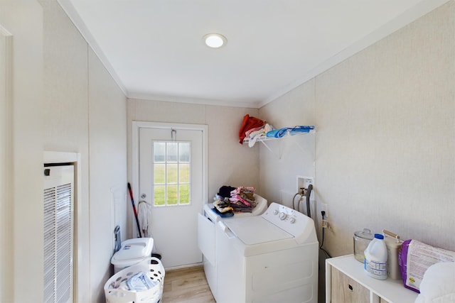 laundry room featuring washer and clothes dryer, light wood-type flooring, and ornamental molding