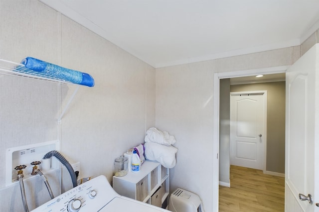 washroom featuring washer / clothes dryer, ornamental molding, and light wood-type flooring