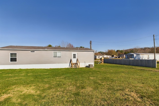 back of property with a lawn and central AC unit