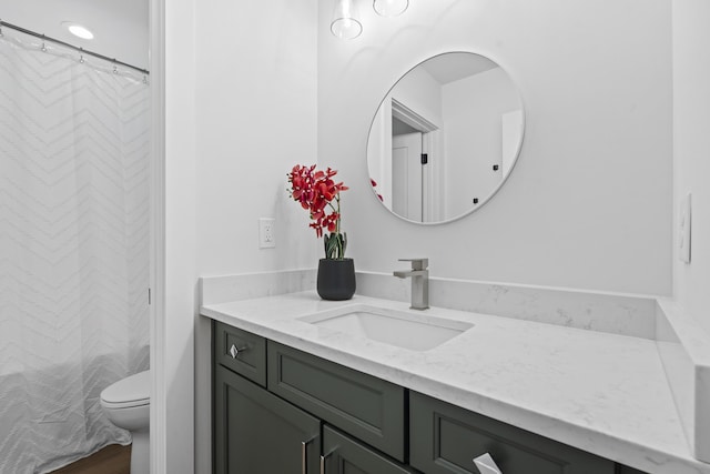 bathroom featuring vanity, toilet, and curtained shower