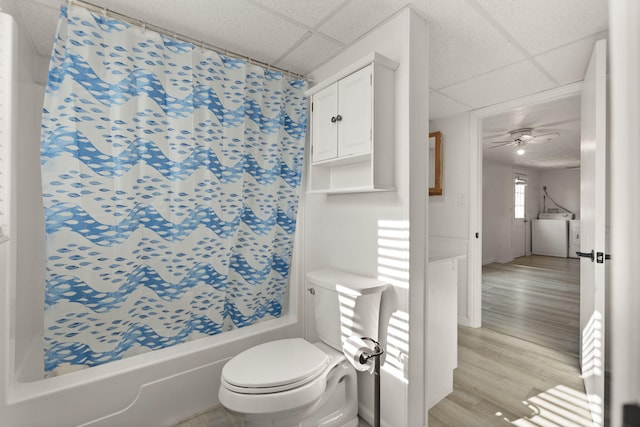 bathroom with bathtub / shower combination, washer and clothes dryer, ceiling fan, hardwood / wood-style floors, and toilet