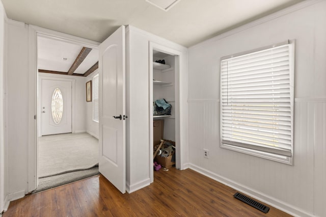 foyer entrance featuring beamed ceiling and dark hardwood / wood-style flooring