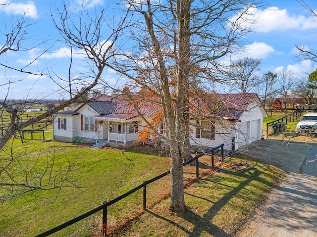 view of front of home featuring a garage, covered porch, an outdoor structure, and a front lawn