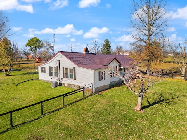 back of property featuring central AC and a yard