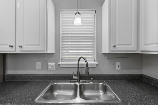 kitchen with white cabinets, decorative light fixtures, and sink