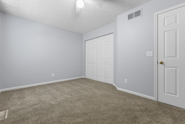 unfurnished bedroom featuring carpet flooring, a textured ceiling, and ceiling fan