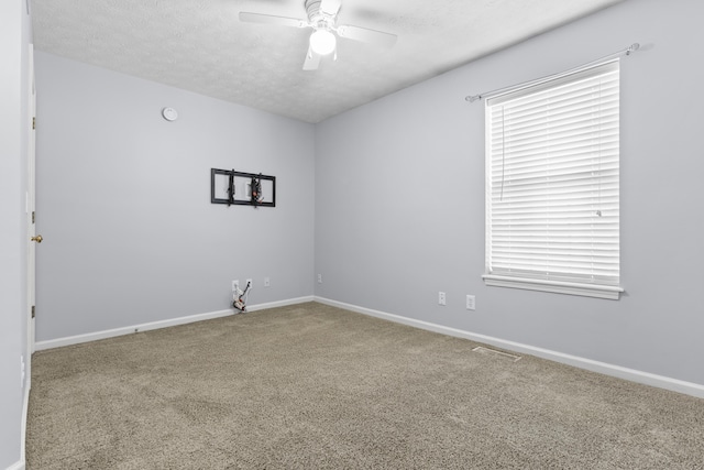 carpeted spare room with ceiling fan and a textured ceiling