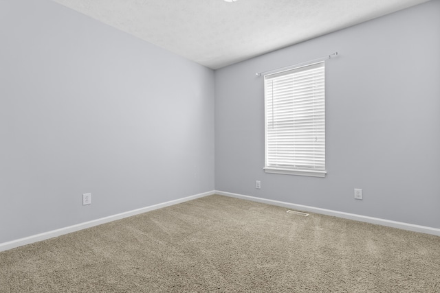 spare room featuring carpet flooring and a textured ceiling