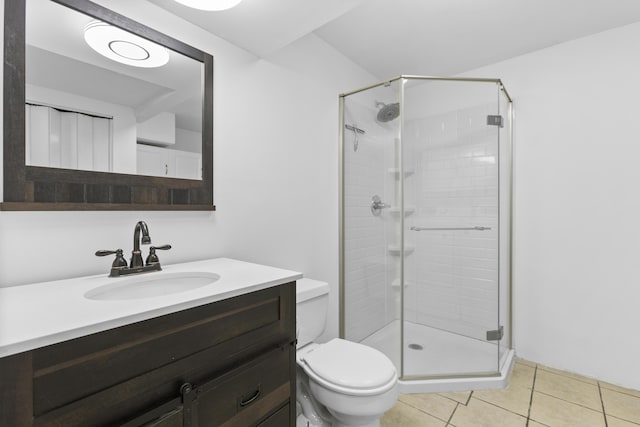 bathroom with tile patterned flooring, vanity, toilet, and walk in shower