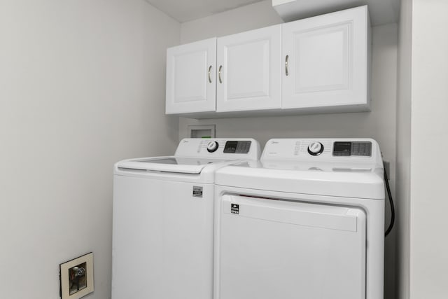 washroom with washer and clothes dryer and cabinets