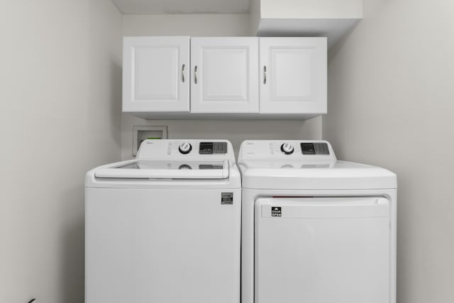 washroom featuring washer and clothes dryer and cabinets