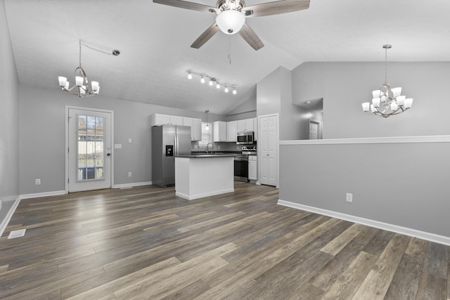 kitchen featuring white cabinetry, dark wood-type flooring, pendant lighting, vaulted ceiling, and appliances with stainless steel finishes