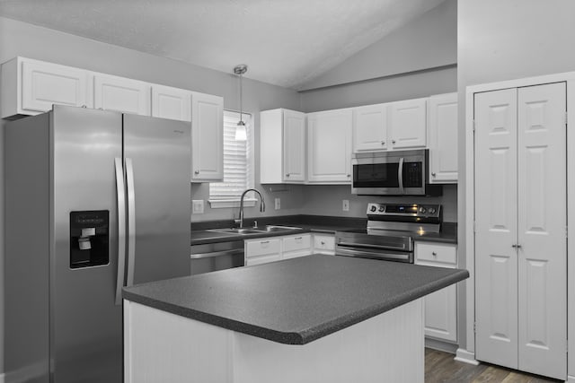 kitchen featuring sink, pendant lighting, lofted ceiling, white cabinets, and appliances with stainless steel finishes