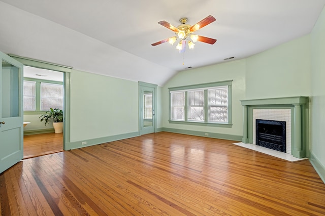 unfurnished living room with lofted ceiling, ceiling fan, hardwood / wood-style flooring, and a healthy amount of sunlight