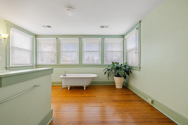 bathroom with hardwood / wood-style flooring and a washtub