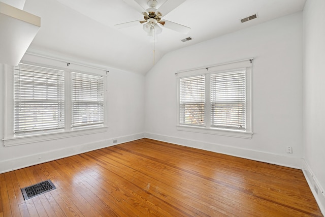 empty room with lofted ceiling, hardwood / wood-style floors, and ceiling fan