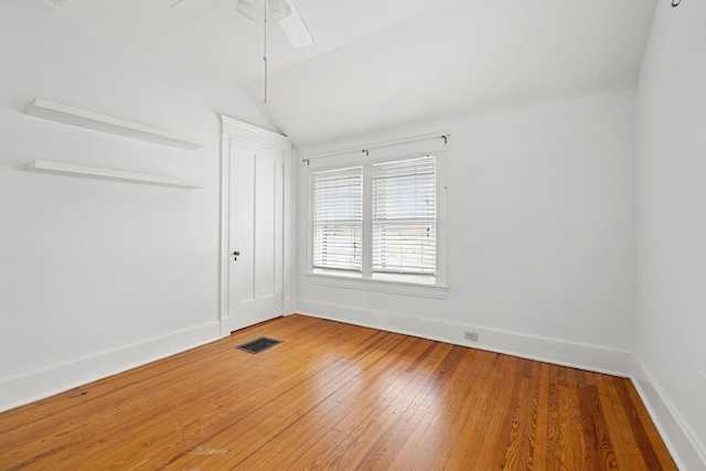 unfurnished room with ceiling fan, lofted ceiling, and wood-type flooring