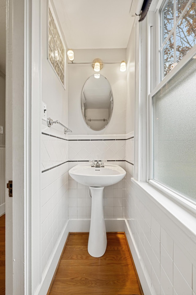 bathroom with hardwood / wood-style floors and tile walls