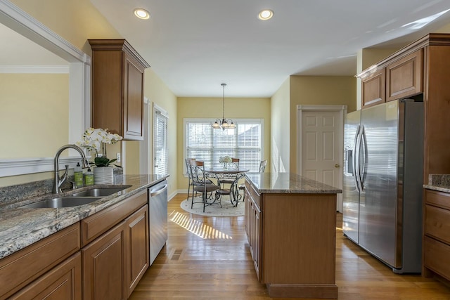 kitchen featuring sink, a kitchen island, light hardwood / wood-style floors, stainless steel appliances, and a chandelier