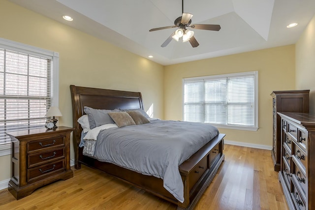 bedroom with light wood-type flooring, multiple windows, lofted ceiling, and ceiling fan