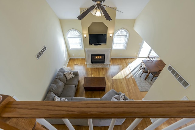 living room featuring ceiling fan, light hardwood / wood-style floors, and lofted ceiling