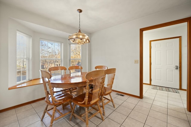 tiled dining area featuring a notable chandelier