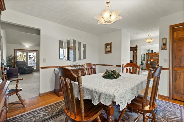 dining room with hardwood / wood-style flooring and a chandelier