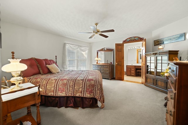 bedroom with multiple windows, ceiling fan, ensuite bath, and light colored carpet