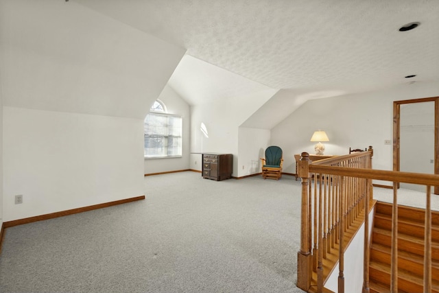 bonus room with carpet floors, a textured ceiling, and vaulted ceiling