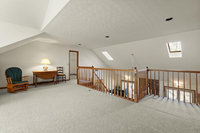 additional living space featuring a textured ceiling, carpet floors, and vaulted ceiling with skylight