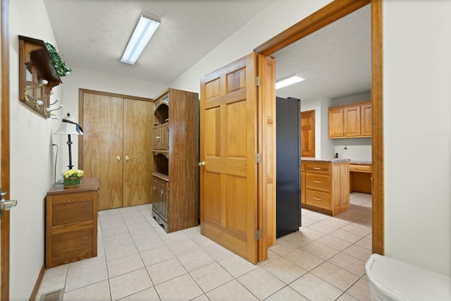 hallway with light tile patterned floors and a textured ceiling