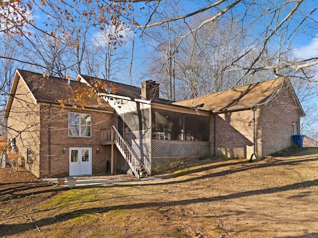 rear view of house featuring a sunroom and french doors