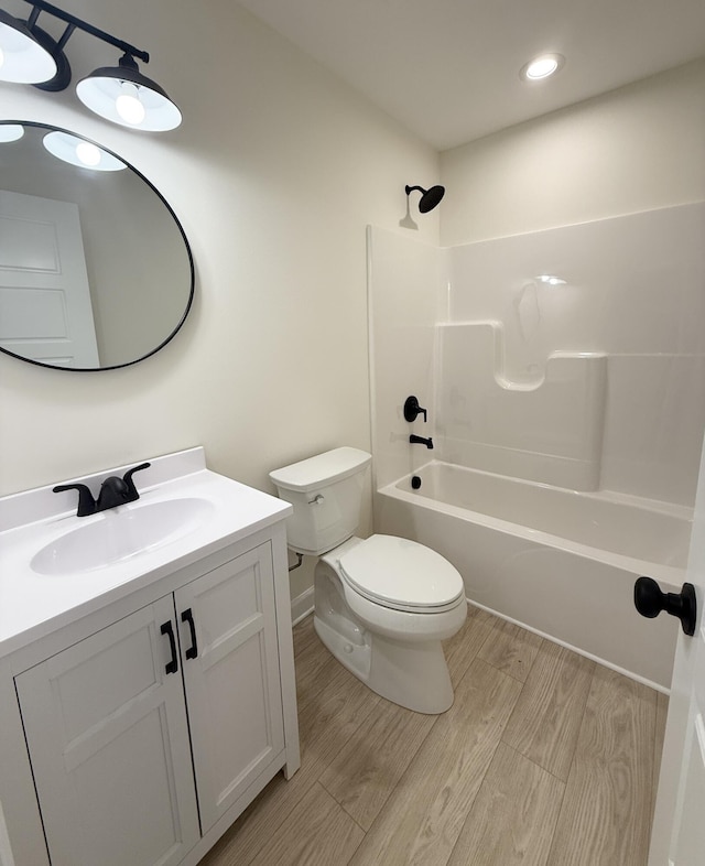 full bathroom featuring vanity, toilet, wood-type flooring, and shower / tub combination