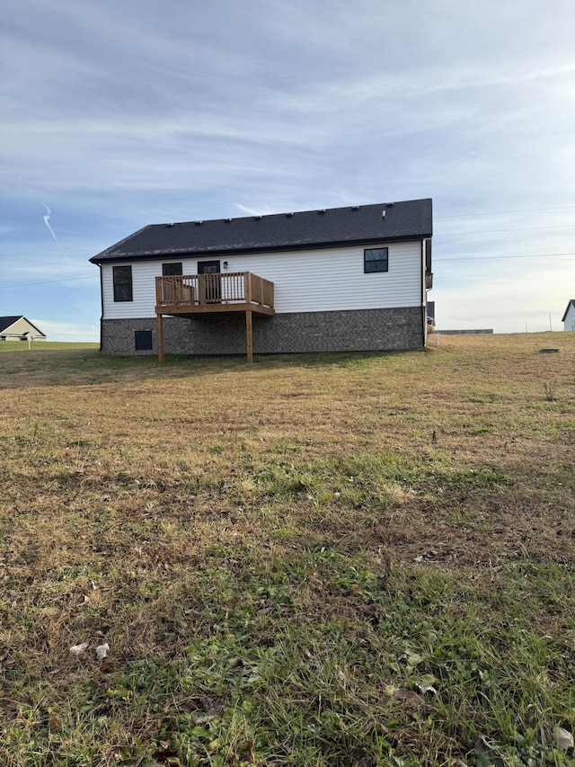 rear view of property featuring a lawn and a wooden deck