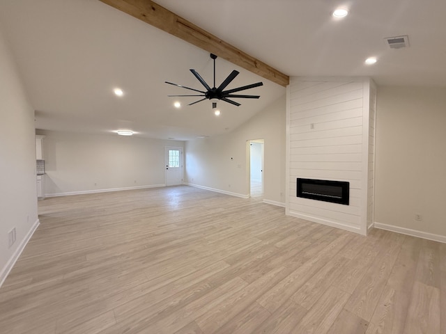 unfurnished living room featuring vaulted ceiling with beams, light hardwood / wood-style floors, ceiling fan, and a large fireplace