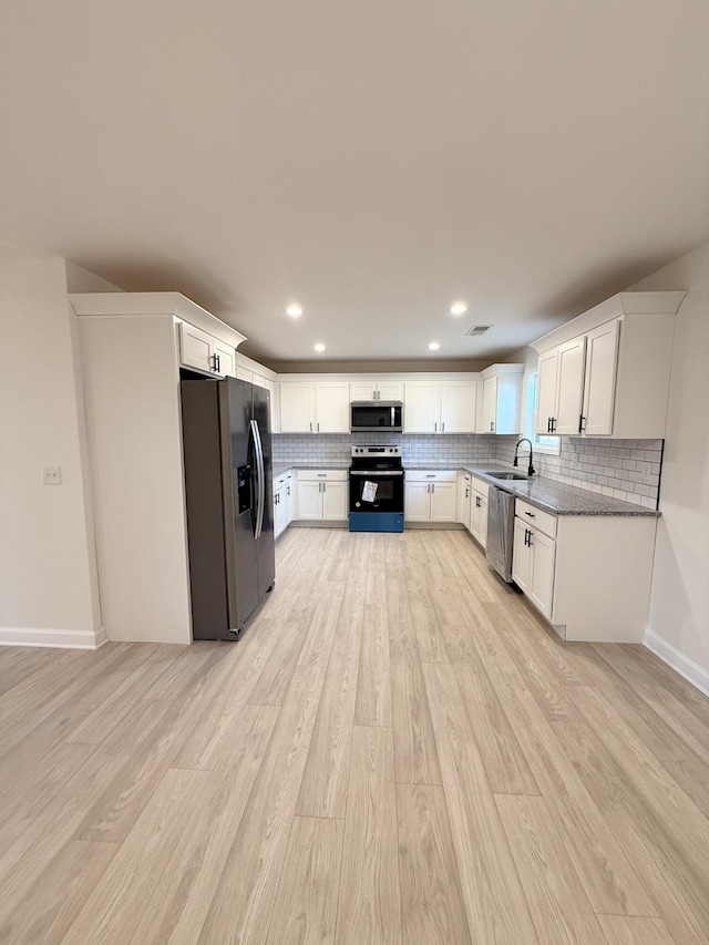 kitchen featuring white cabinets, sink, light wood-type flooring, and stainless steel appliances