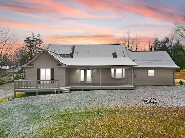 back house at dusk featuring a wooden deck