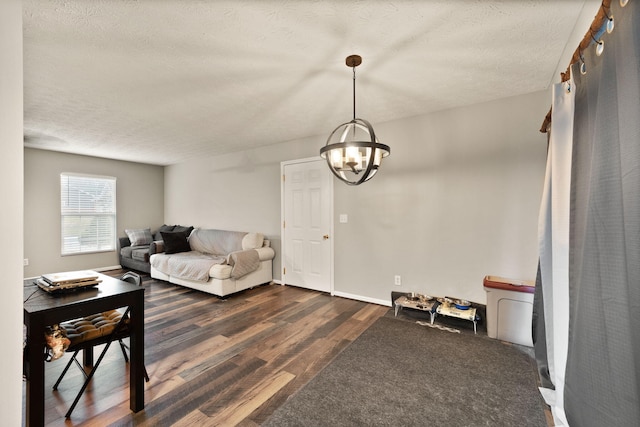 living room with a chandelier, a textured ceiling, and dark wood-type flooring