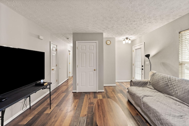 living room with a textured ceiling and dark hardwood / wood-style flooring