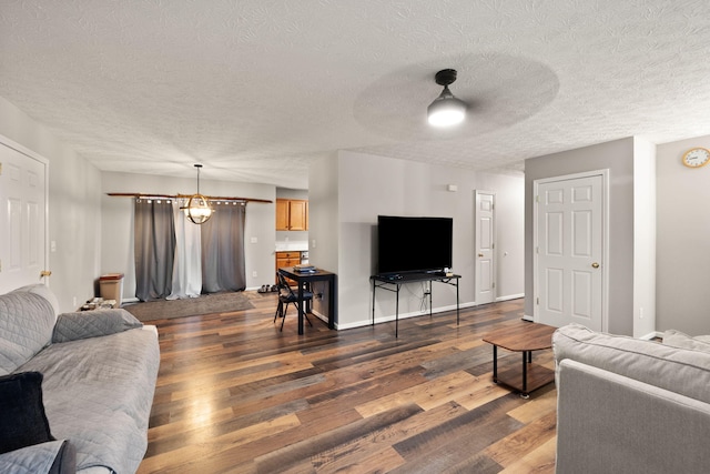 living room featuring a textured ceiling, dark hardwood / wood-style flooring, and ceiling fan with notable chandelier