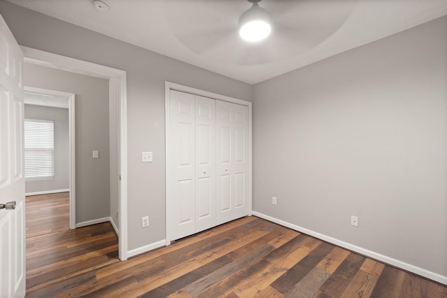 unfurnished bedroom featuring a closet, dark hardwood / wood-style floors, and ceiling fan