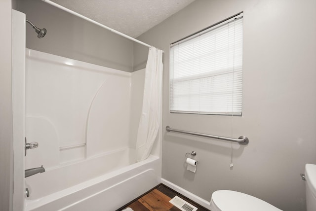 bathroom with shower / bath combination with curtain, toilet, wood-type flooring, and a textured ceiling