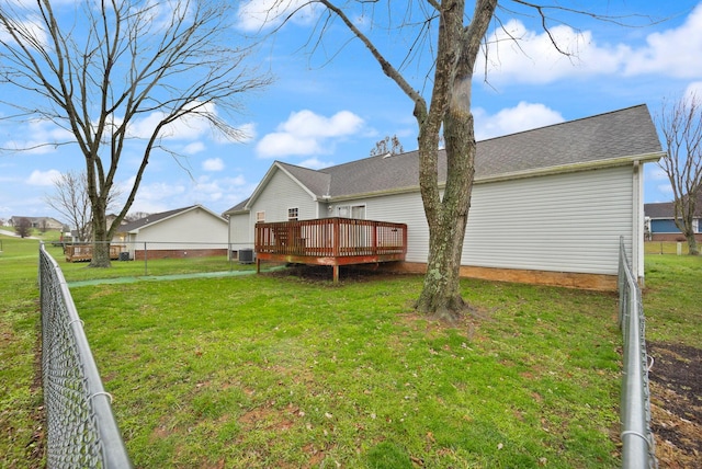 rear view of house with a lawn, central AC unit, and a wooden deck