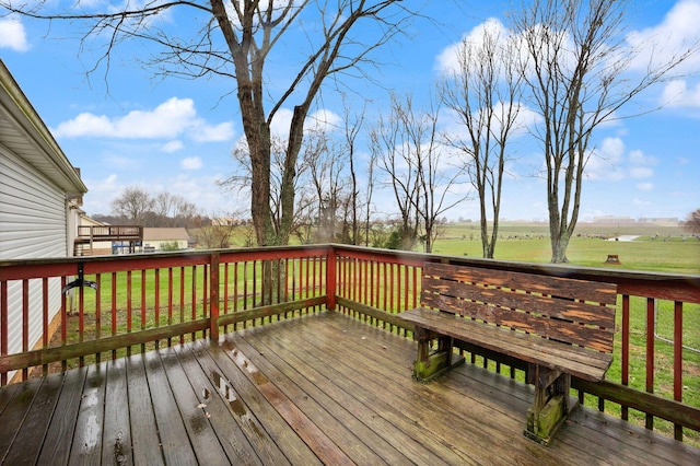 wooden deck with a lawn and a rural view