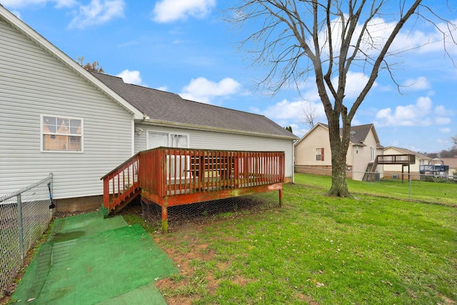 rear view of house featuring a yard and a deck