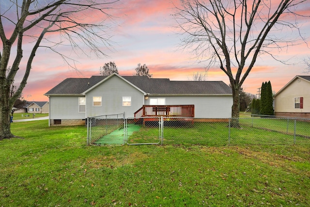 back house at dusk featuring a deck and a yard