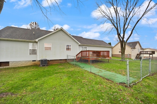 back of property with central AC unit, a wooden deck, and a lawn