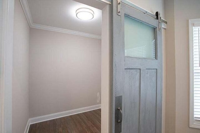 details featuring a barn door, wood-type flooring, and ornamental molding