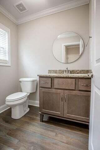 bathroom featuring hardwood / wood-style floors, vanity, toilet, and crown molding